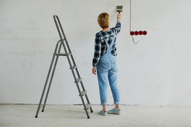 Junge Frau macht Reparaturen in ihrem Haus