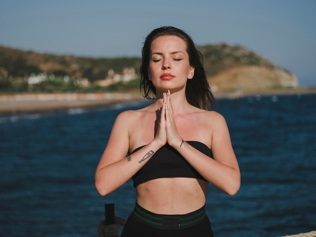 junge Frau macht Yoga am Strand