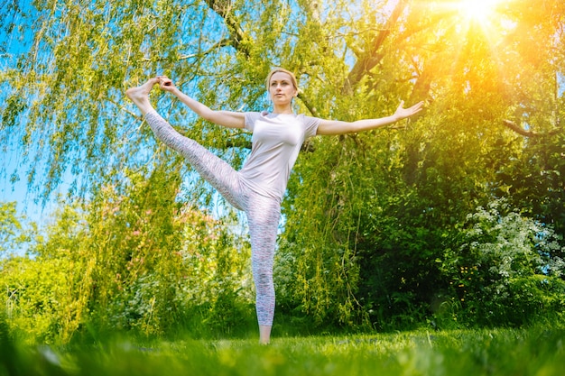Junge Frau macht Yoga Asana im Park Mädchen Dehnübungen in Yogaposition
