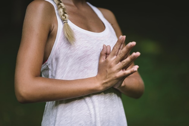 Junge Frau macht Yoga und meditiert mit den Händen in Gebetsposition