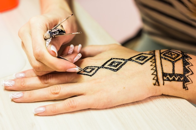 junge Frau Mehendi Künstler Malerei Henna auf der Hand.