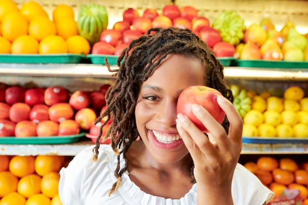 Junge Frau mit Apfel im Laden