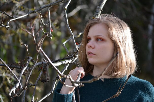 Foto junge frau mit baumzweig im wald