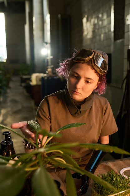 Junge Frau mit Behinderung kümmert sich um eine Hauspflanze