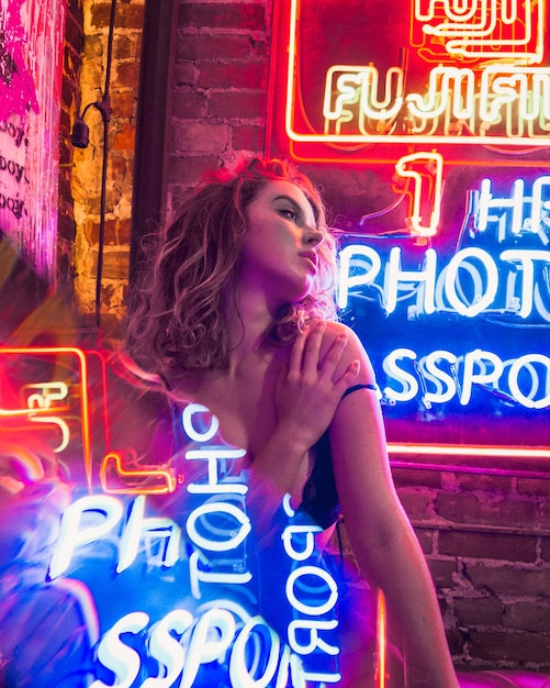 Foto junge frau mit beleuchtetem neonschild