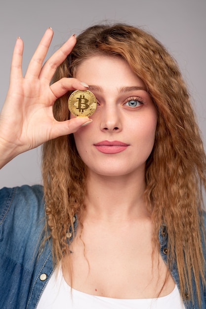 Junge Frau mit Bitcoin-Münze