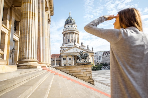 Junge Frau mit Blick auf die französische Kirche in der Nähe des Konzerthauses in Berlin. Bild fokussiert auf den Hintergrund