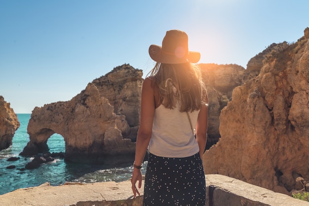 Junge Frau mit Blick auf die Höhlen von Ponta da Piedade.