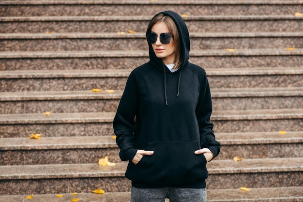 Junge Frau mit Brille und schwarzem Hoodie