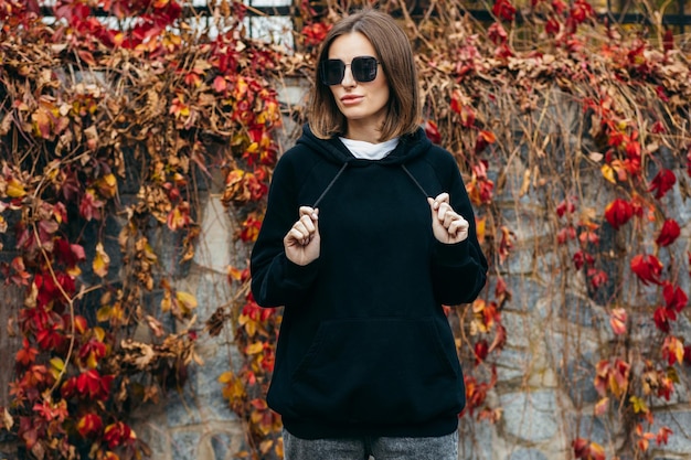 Junge Frau mit Brille und schwarzem Hoodie