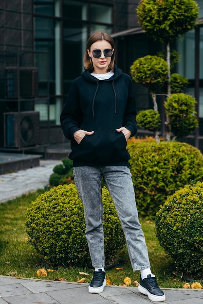 Junge Frau mit Brille und schwarzem Hoodie