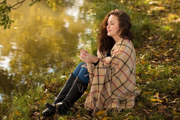 Junge Frau mit Decke im Park im Herbst