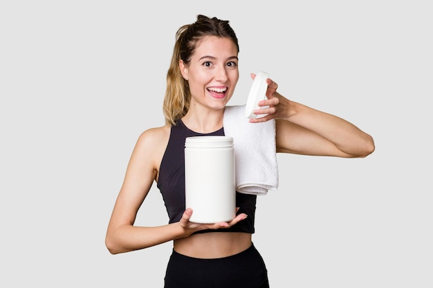 Junge Frau mit einem Behälter mit Proteinpulver in Sportkleidung
