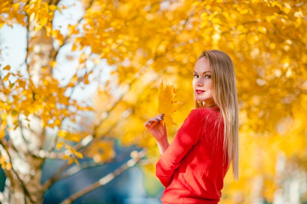 Junge Frau mit einem Blatt im Herbstpark