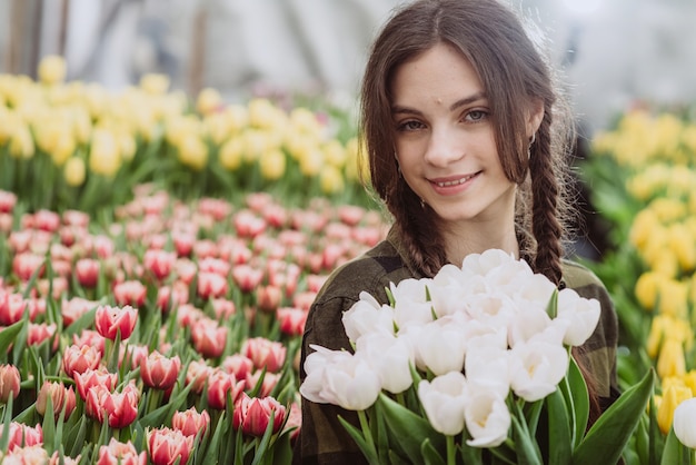 Junge Frau mit einem Blumenstrauß der Frühlingsblumen Tulpen.