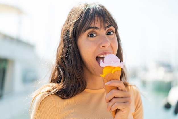 Junge Frau mit einem Cornet-Eis im Freien