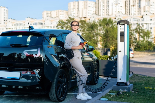 Junge Frau mit einem Elektroauto an der Ladestation in Chisinau Moldawien