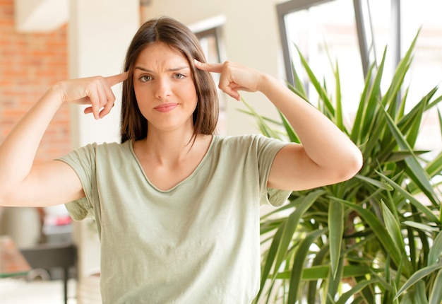 Junge Frau mit einem ernsten und konzentrierten Blick Brainstorming und Nachdenken über ein herausforderndes Problem