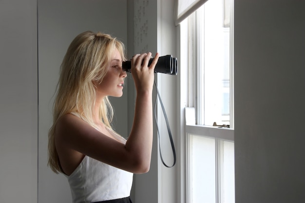 Junge Frau mit einem Fernglas