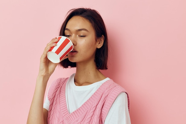 Junge Frau mit einem Glas in der Hand Sommer Stil rosa T-Shirt Lifestyle unverändert