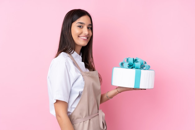 Junge Frau mit einem großen Kuchen über viel lächelnd