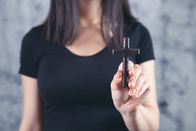 Junge Frau mit einem Holzkreuz