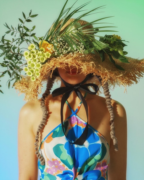 Foto junge frau mit einem hut voller blumen