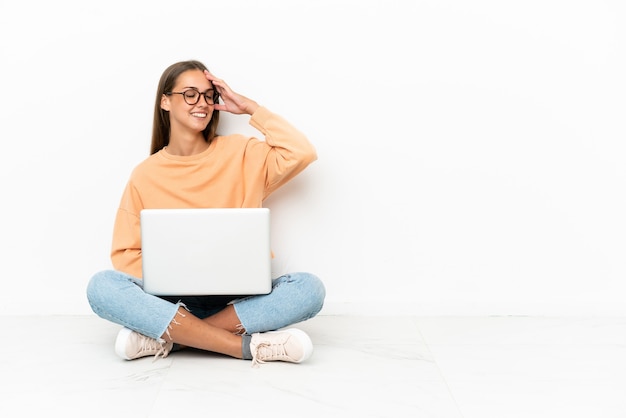 Junge Frau mit einem Laptop auf dem Boden sitzend hat etwas erkannt und beabsichtigt die Lösung