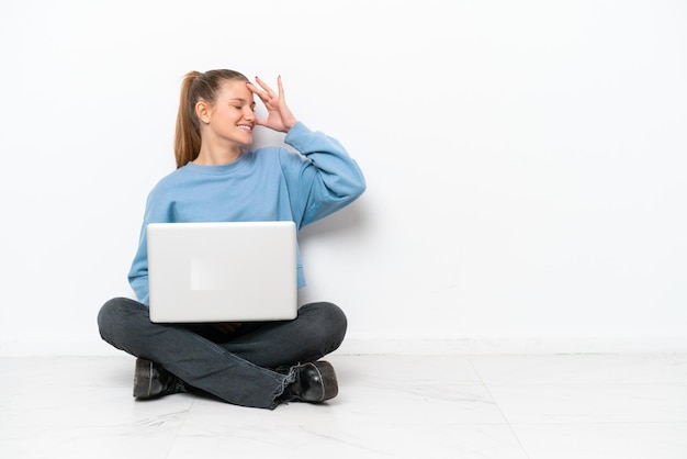 Junge Frau mit einem Laptop auf dem Boden sitzend hat etwas erkannt und beabsichtigt die Lösung