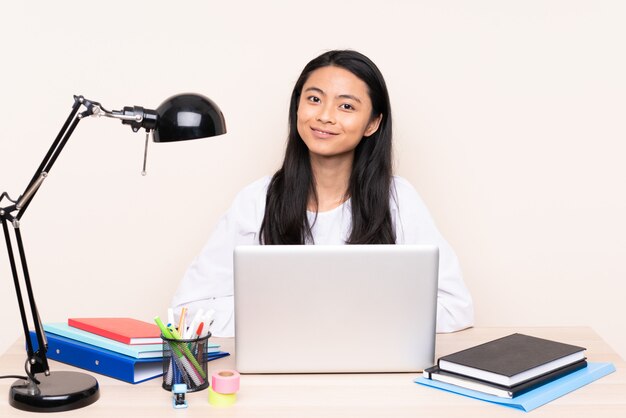 Junge Frau mit einem Laptop, der an einem Tisch sitzt