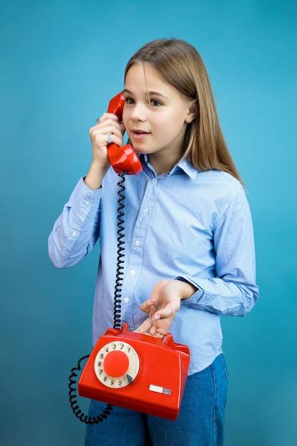 Junge Frau mit einem roten Retro-Telefon in ihren Händen