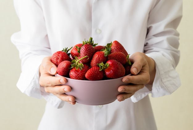 Junge Frau mit einer Schüssel frische süße Erdbeeren