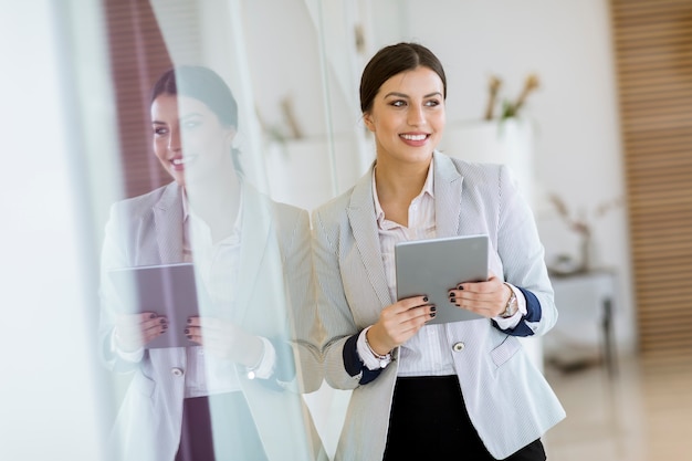 Junge Frau mit einer Tablette im Büro