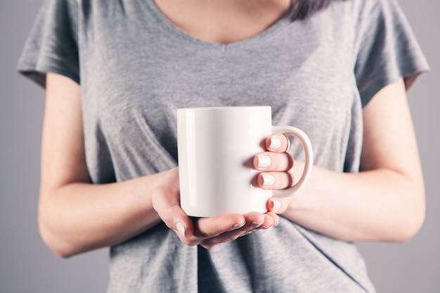 Junge Frau mit einer weißen Tasse