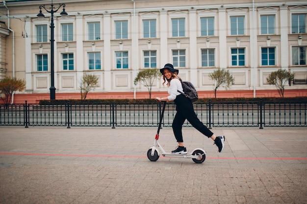 Junge Frau mit Elektroroller an der Stadt