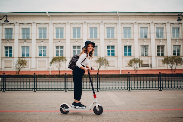 Junge Frau mit Elektroroller an der Stadt