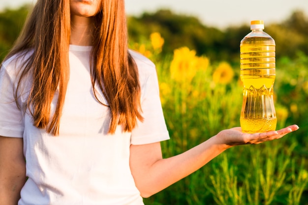 Junge Frau mit Flasche Sonnenblumenöl