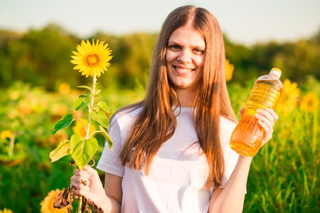 Junge Frau mit Flasche Sonnenblumenöl