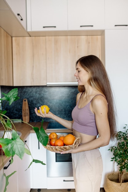 Junge Frau mit Früchten in der Küche Gesundes veganes Essen zu Hause