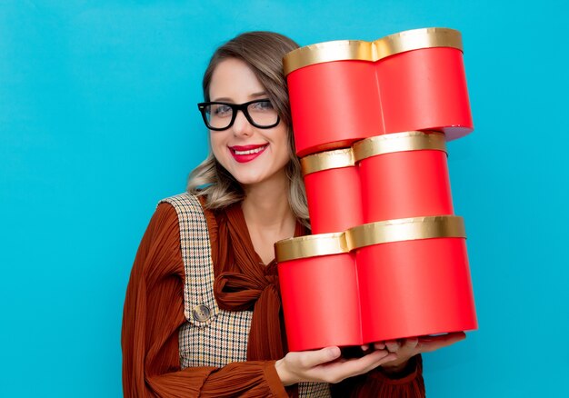 Junge Frau mit Geschenkboxen auf blau