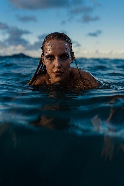 Foto junge frau mit goldener haut im wasser