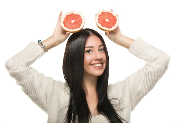 Junge Frau mit Grapefruit in ihren Händen Studioporträt lokalisiert auf weißem Hintergrund