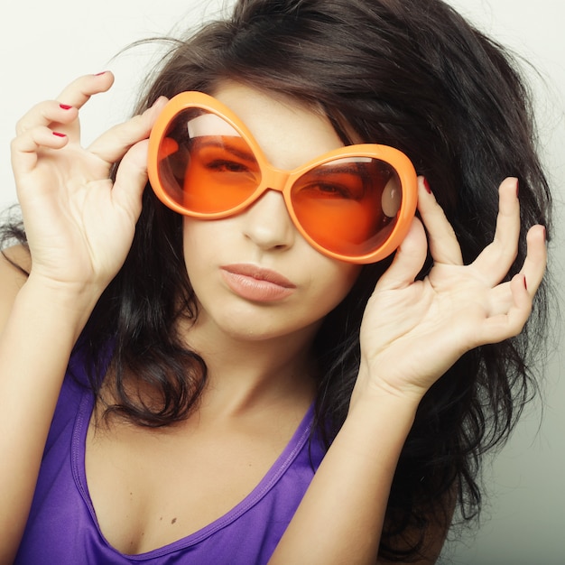 Junge Frau mit großer orange Sonnenbrille