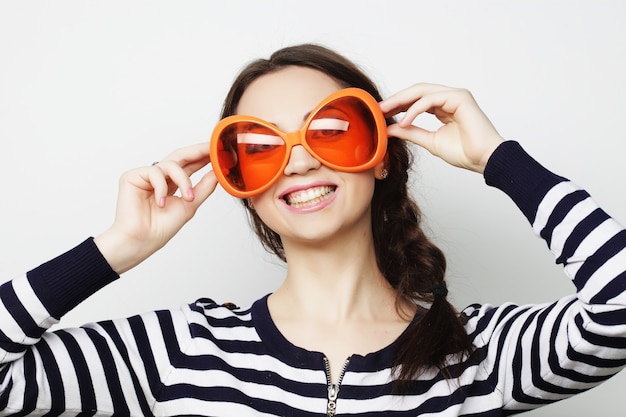 Junge Frau mit großer orange Sonnenbrille