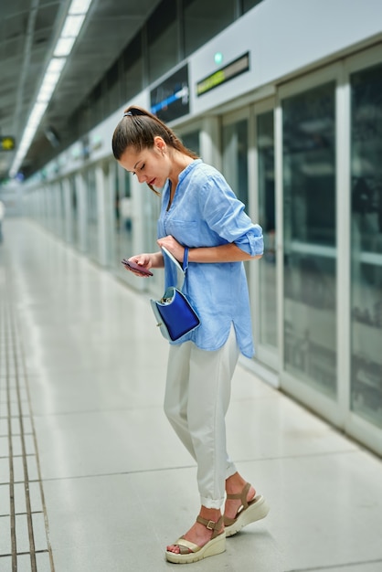Junge Frau mit Handtasche in der U-Bahnstation.