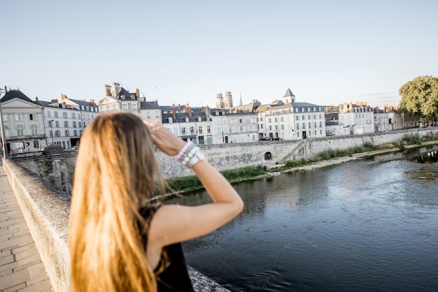 Junge Frau mit herrlichem Blick auf das Stadtbild während des Sonnenuntergangs in der Stadt Orleans, Frankreich