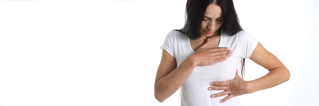 Junge Frau mit Herz- und Brustschmerzen auf weißem Hintergrund Brustschmerzen plötzliches und akutes Konzept