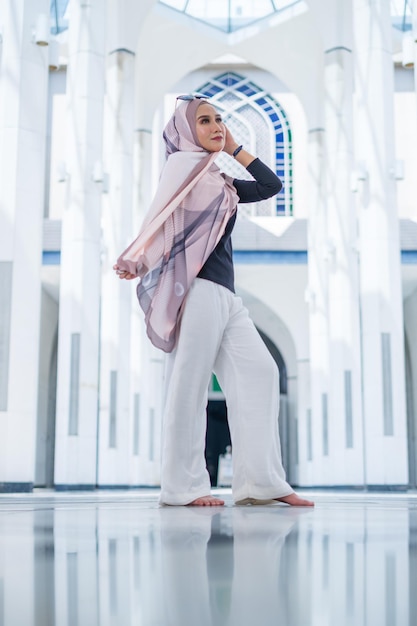 Junge Frau mit Hijab, die im Korridor steht