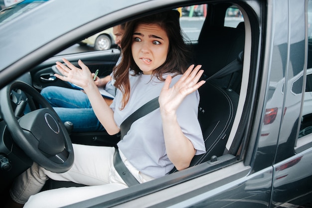 Junge Frau mit ihrem Autolehrer in einem Auto