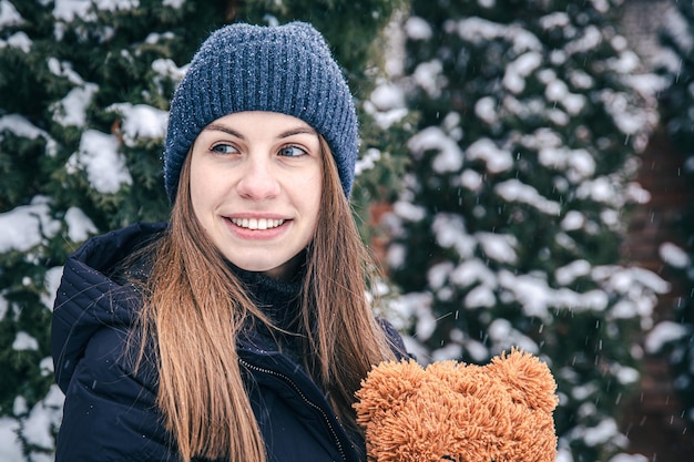 Junge Frau mit ihrem Lieblings-Teddybär im Arm im Winter